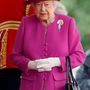 Magenta rózsaszín kabát és kalap fehér kesztyűvel a londoni Horse Guards Parádén.