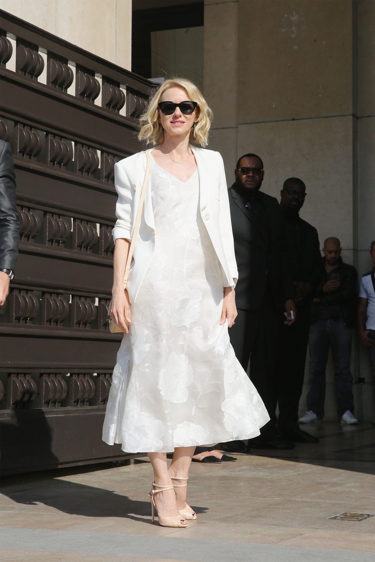 A 90-es évek stílusát idéző ujjatlan fehér ruha és lapos talpú szandál Elizabeth von Guttmanon.