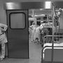 Az operálóhelyiség előterében telefonáló orvos mögött igazi csapatmunka folyik a műtőben 1986-ban