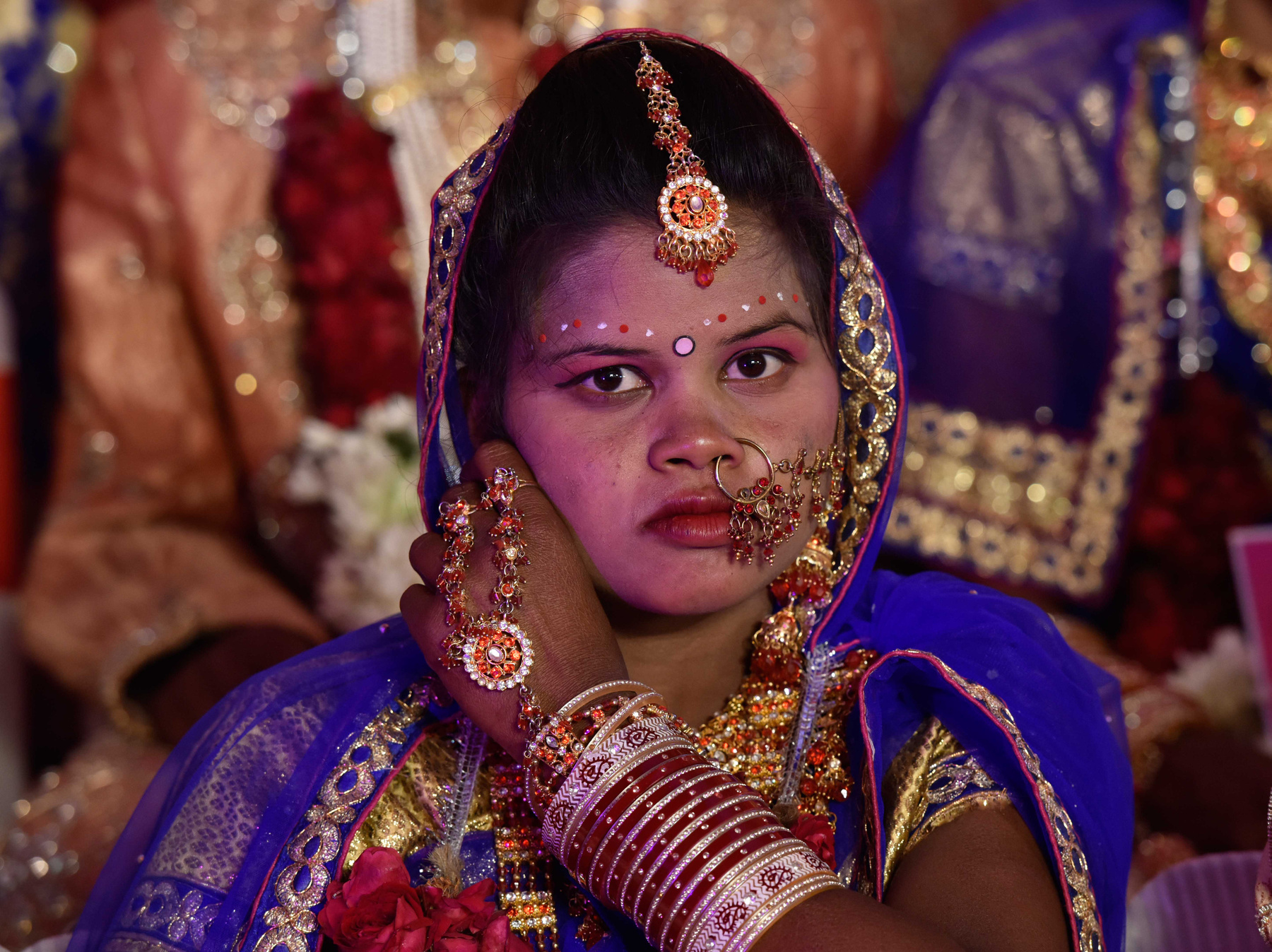 Bár illegális, mégis gyakori a gyermekházasság Indiában. A szemmel láthatóan még gyereklány kezében a saját gyermekét tartja.  Aki nem az elsőszülött, ugyanis a háta mögött ülő kisfiú is az övé.