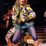 Törpesarkú bokacsizma, lila csipke leggings, túlméretezett csicsás kabát és sárgára festett körmök az 1985-ös 'The Virgin Tour' koncerten.


