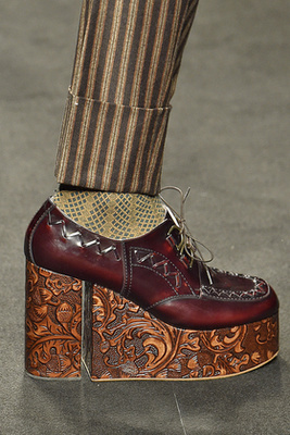 Fekete pánttal díszített bőr cipő a Versace kifutóján.