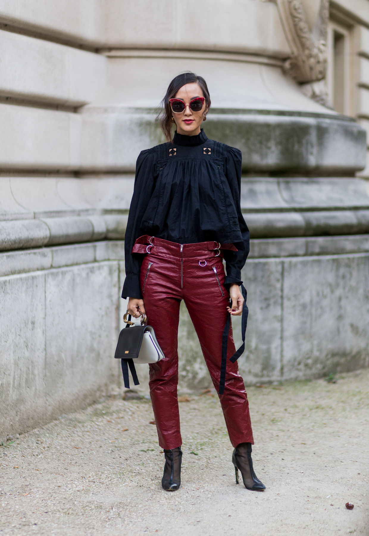 Chriselle Lim bordó bőrnadrággal kombinálta a fekete blúzt Párizsban.

